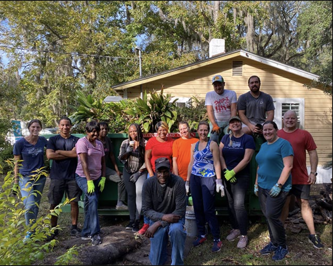 Group photo of volunteers posing outside a home restoration project.